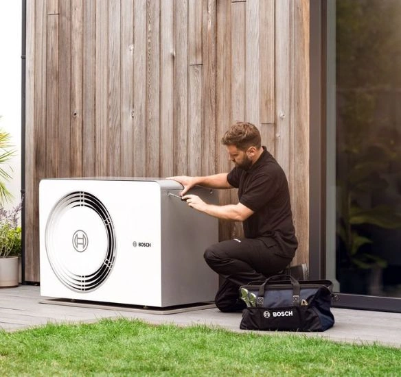 Installer working on CS5800 heat pump outside
